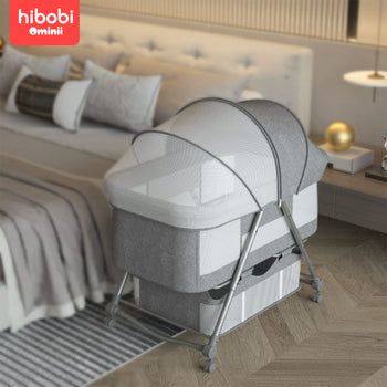 Hibobi Ominni Baby Side Bed, Newborn Foldable Bed, Crib with Large Storage Basket, Portable Infant Bed with Side Net for Travel, Adjustable High with Soft Mattress, Swivel Wheels and Anti-Mosquito Net.